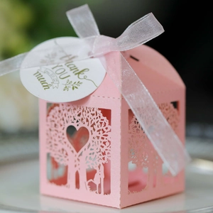 Detail of pink laser-cut wedding favor box with love tree design and thank you tag