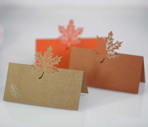 Detailed close-up of laser-cut maple leaf place cards in orange and brown tones