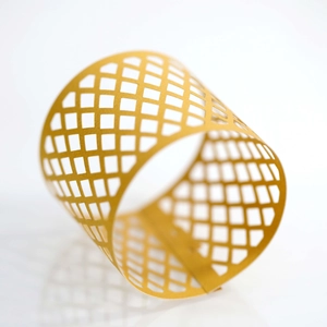 Close-up of golden laser-cut hollow grid paper lampshade with precise square patterns