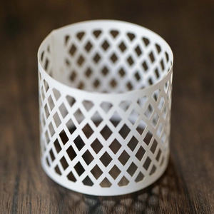 Close-up of white laser-cut paper candle holder featuring elegant diamond lattice pattern