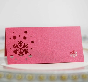 Close-up of laser-cut snowflake place card in pearlescent pink for Christmas decor