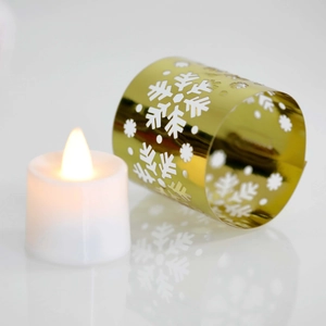 Detail of gold snowflake cutout decorative sleeve with LED candle for Christmas