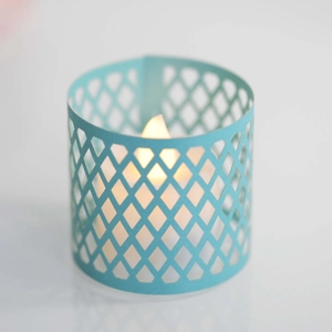 Detail of teal diamond lattice hollow lampshade with warm glowing LED tea light candle