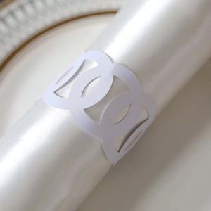 Macro detail of laser-cut white paper napkin ring with geometric circular hollow design