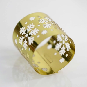 Detail of laser-cut golden snowflake napkin ring with a reflective metallic finish