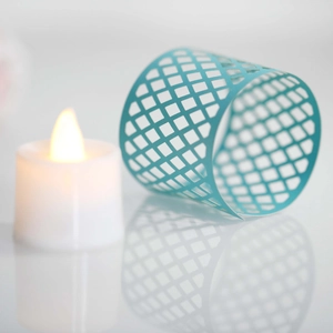 Macro shot of blue diamond-grid cutouts on cylindrical LED candle sleeve decor