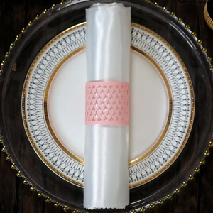Macro detail of laser-cut pink paper napkin ring with elegant hollow grid pattern