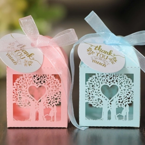 Detail of laser-cut heart tree candy boxes with ribbon bows and thank you tags