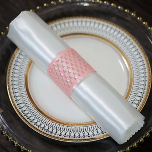 Detail of pink laser-cut hollow pattern napkin ring for elegant wedding table decor