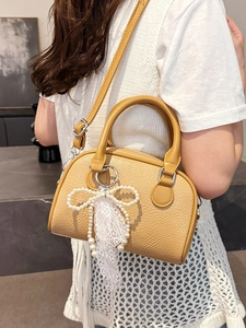 Elegant yellow lychee texture Boston handbag featuring pearl bow and lace charm pendant