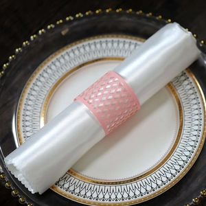Pink laser-cut grid napkin ring on white satin napkin over luxury ceramic plate