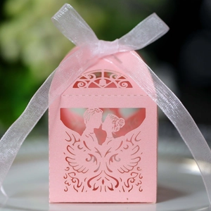 Nahaufnahme der lasergeschnittenen rosa Hochzeits-Geschenkbox mit Herzmotiv und weißer Schleife