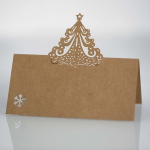 Detail of laser-cut Christmas tree and snowflake patterns on kraft paper place cards