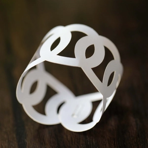 Macro shot of laser-cut white paper napkin ring with elegant hollow circular pattern