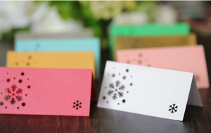 Detail of laser-cut snowflake place cards in multiple colors for Christmas table decor