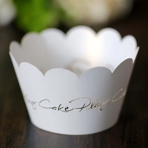 Primer plano de envoltorio blanco para cupcakes con elegante diseño calado de Cake Play