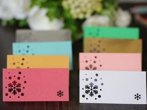 Macro view of laser-cut snowflake place cards in various colors for Christmas parties