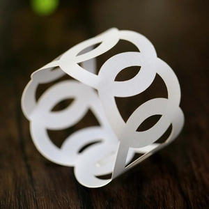 Detailed view of white laser-cut hollow rings with geometric patterns for napkins