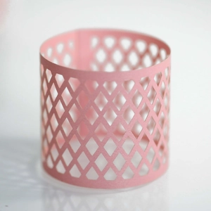 Detail of pink hollow grid paper lampshade with laser-cut diamond pattern for LED candles