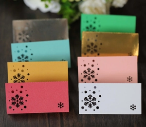 Macro view of assorted colorful snowflake place cards with laser cut detail on wood