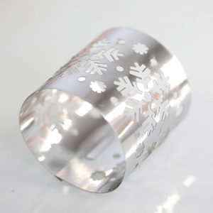 Macro shot of silver metal napkin ring featuring detailed laser-cut snowflake pattern
