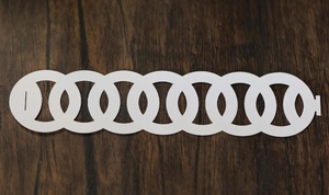 Detailed view of white paper napkin rings with interlocking geometric circular cutouts