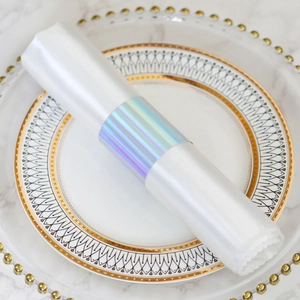 Iridescent napkin ring with colorful metallic finish on white dinner plate