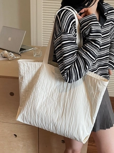Minimalist large white tote bag with vertical pleated texture shown in a home office setting