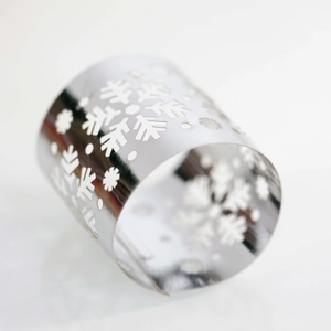Detailed view of mirror-polished silver metal snowflake napkin ring with laser-cut hollow pattern