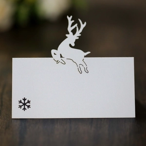 Macro shot of white laser-cut Christmas reindeer place card with snowflake print detail