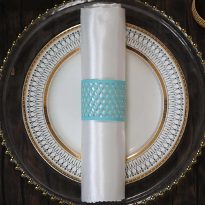 Detail of sky blue laser-cut geometric napkin ring on a white satin napkin for wedding decor