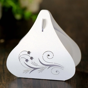 Macro detail of white pearlescent wedding favor box with laser-cut floral patterns