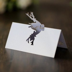 Close-up of laser-cut reindeer and snowflake details on white foldable place cards