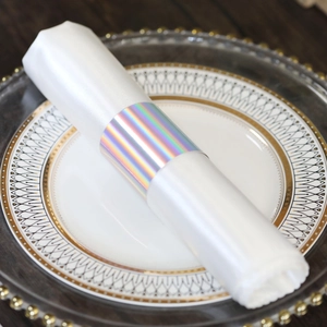Macro shot of iridescent silver napkin ring with laser coating on a white linen napkin