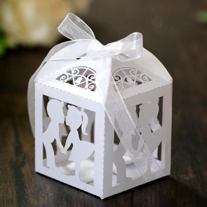Détail de boîte à bonbons de mariage découpée au laser avec silhouette et ruban blanc