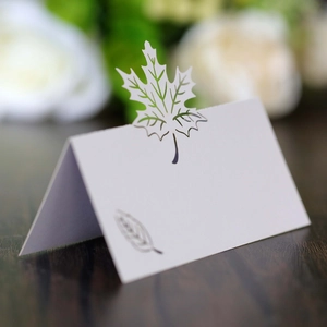 Macro detail of laser-cut maple leaf place card with elegant folding tent design