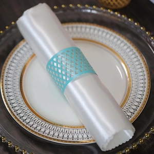 Detail of laser-cut light blue napkin ring with geometric pattern on white satin