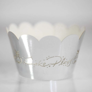 Close-up of silver laser-cut cupcake wrapper with Cake Play hollow design for parties