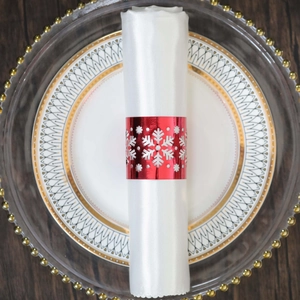 Detail shot of a festive red hollow snowflake napkin ring on a white linen napkin