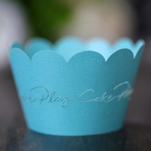 Vista macro de moldes de papel azul cielo para cupcakes con bordes ondulados y diseño cortado
