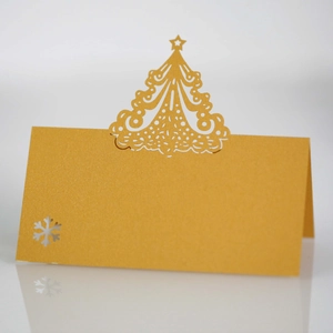 Detail of laser-cut gold pearlescent Christmas tree table card with snowflake patterns