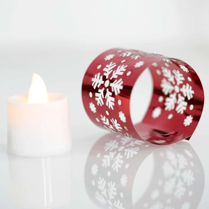 Close-up of red hollow snowflake metal candle ring with white LED electronic candle