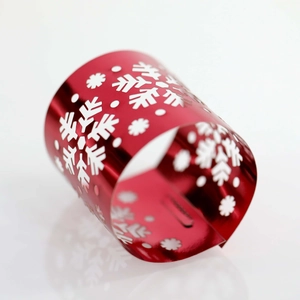 Detail of red hollowed-out napkin ring with white snowflake pattern for Christmas