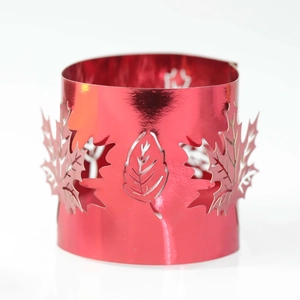 Detail of red hollow maple leaf laser-cut metal candle holder with polished finish