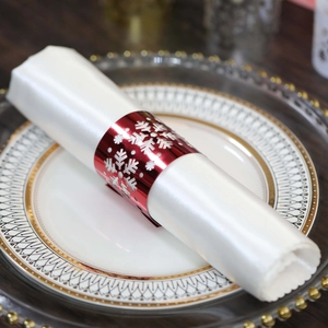 Macro detail of red metallic snowflake napkin ring on elegant dinner plate