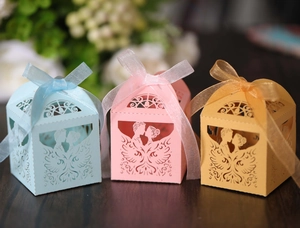 Detail von lasergeschnittenen Hochzeits-Geschenkboxen in Blau Rosa und Gelb mit Schleifen