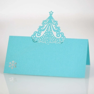Macro detail of laser-cut snowflake place card with elegant Christmas tree cutout