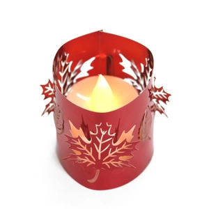 Close-up of red maple leaf laser-cut metal shade with LED candle for autumn decor