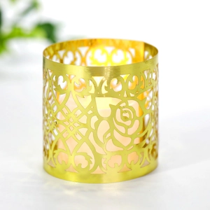 Dettaglio del portacandele in metallo dorato con intaglio a rosa e luce LED calda