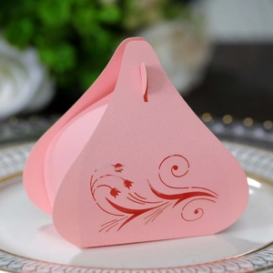 Close-up of pink tulip cutout candy box for weddings on a decorative white plate